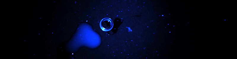 Met UV-licht is olie op een ferrule of een oppervlak te zien als een witte waas. De blauwe spikkels zijn stofdeeltjes.